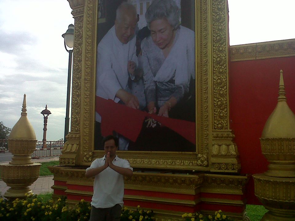 Di depan baliho pasangan mendiang Norodom Sihanouk dan Ratu Monineath. Negara pengimpor minyak.